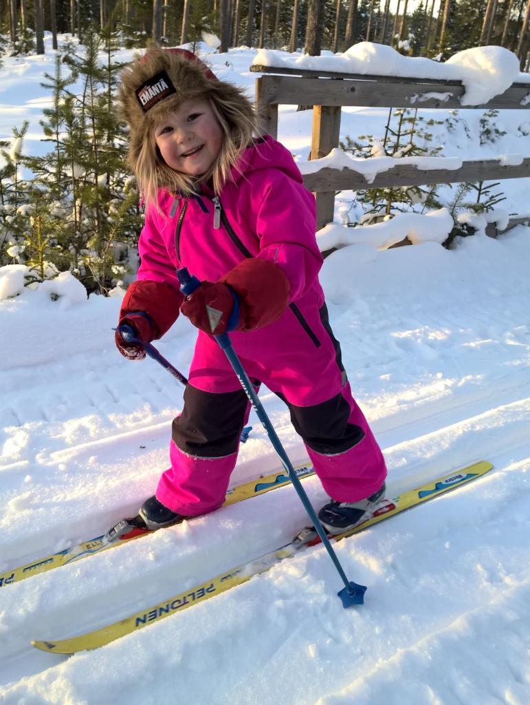 Iloinen tyttö hiihtää Luohualla