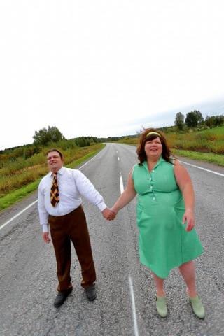 Mies ja nainen käsi kädessä tiellä
