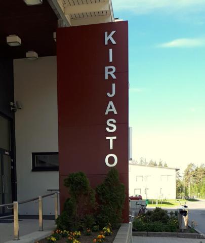 Ruukin pääkirjaston pääovi sivusuunnasta ja kirjaston kyltti
